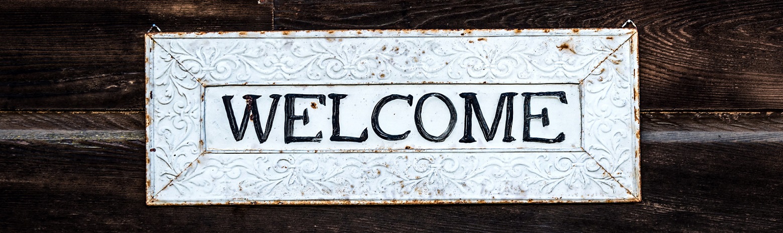 Metal Welcome Sign with dark wood background