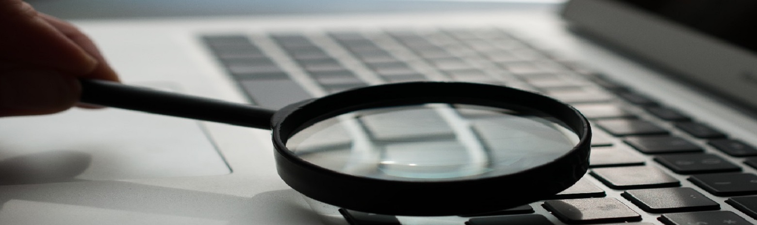 Magnifying glass near grey laptop