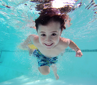 A picture of a young boy swimming under water.