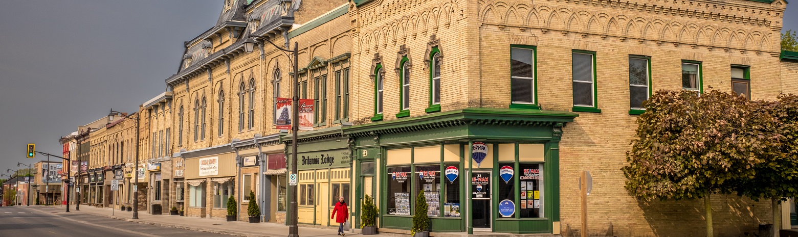 A picture of buildings in downtown Seaforth with a lady walking on the sidewalk.