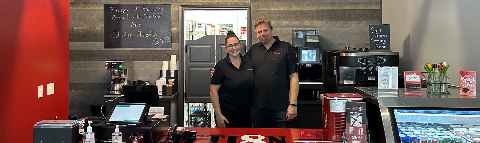 Owners of Junction 8 standing at their restaurant counter.