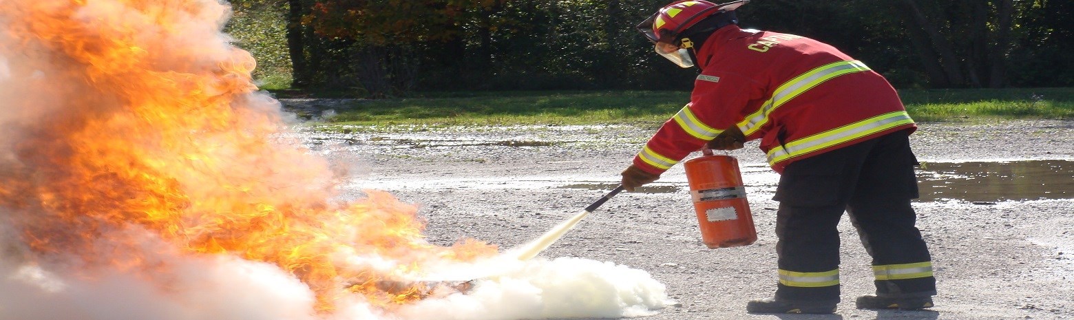 Fire fighter using fire extinguisher to put out a fire 