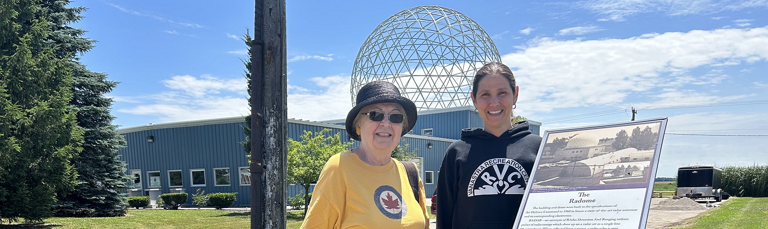 A picture of two women standing beside the plaque about the Radome on the Vanastra Heritage Trail.