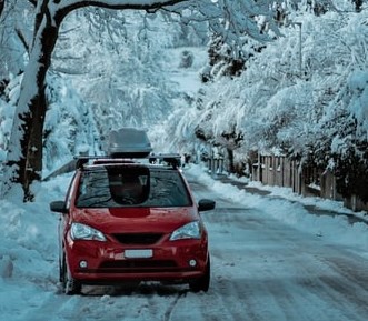 A red car parked along a snowy street
