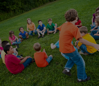 A picture of children sitting around a circle. 