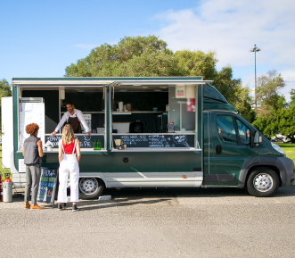 People ordering from a green food truck