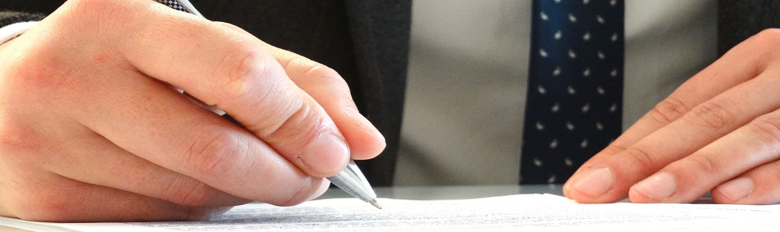Up close picture of man signing a document