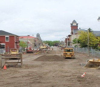 Looking down Main Street with two backhoes on either side of road during road construction